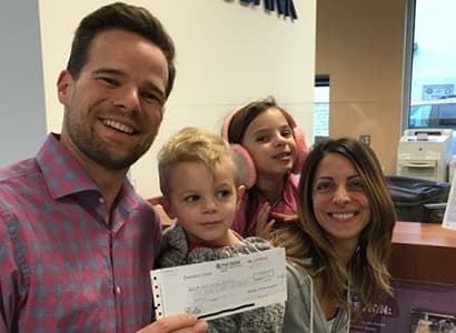 Andy, Nicole, and the kids with their final mortgage payment check at the bank
